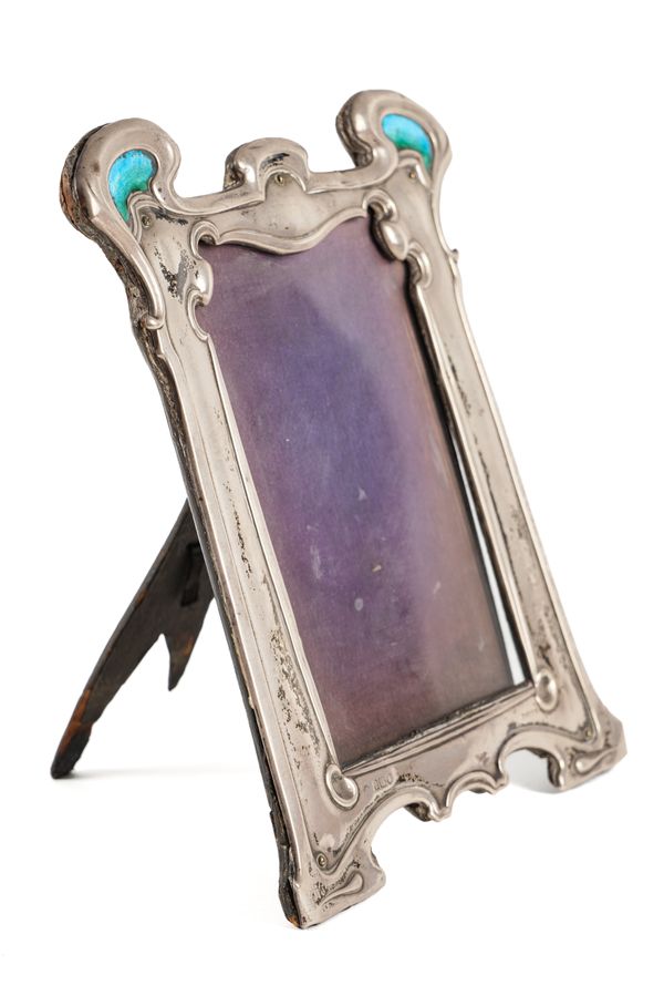 A SILVER AND ENAMEL MOUNTED SHAPED RECTANGULAR ART NOUVEAU PHOTOGRAPH FRAME