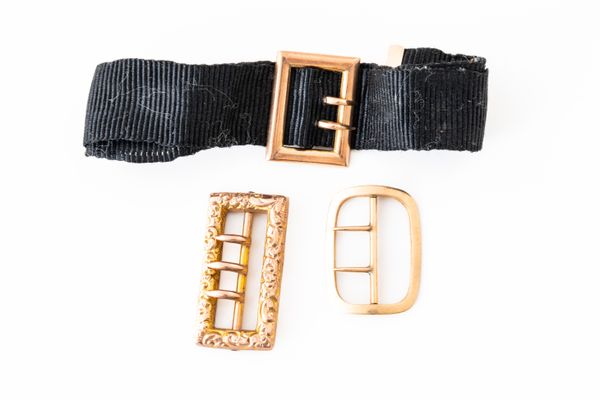 A GOLD MOUNTED BLACK RIBBON WATCH CHAIN AND TWO GOLD BUCKLES (3)