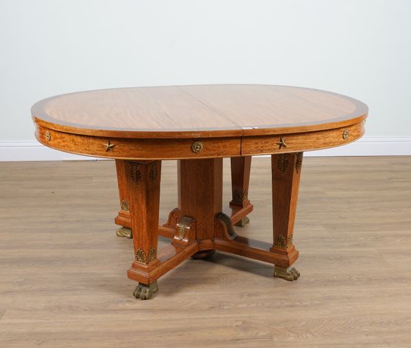 AN EMPIRE REVIVAL ORMOLU MOUNTED AMBOYNA BANDED SATINWOOD OVAL EXTENDING DINING TABLE