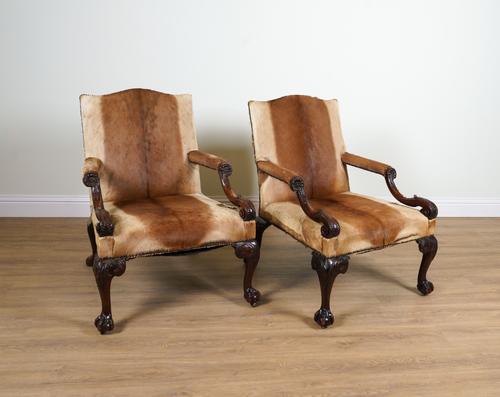A PAIR OF CARVED MAHOGANY FRAMED OPEN ARM GAINSBOROUGH CHAIRS (2)