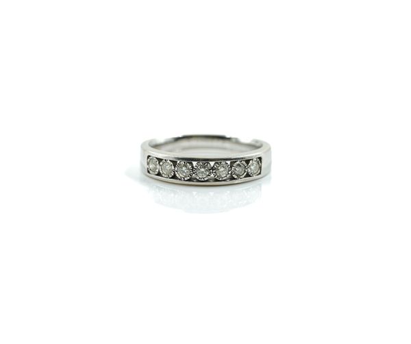 A 9CT WHITE GOLD AND DIAMOND SEVEN STONE HALF HOOP RING