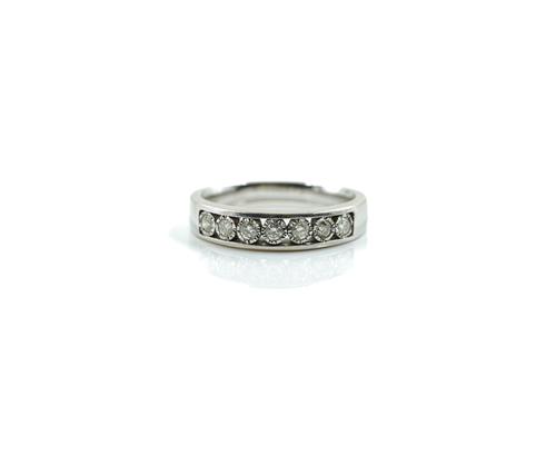 A 9CT WHITE GOLD AND DIAMOND SEVEN STONE HALF HOOP RING