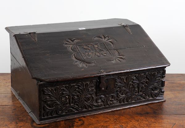 AN EARLY 18TH CENTURY CARVED OAK SLOPE FRONT BIBLE BOX