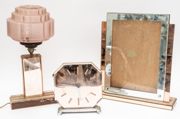 AN ART DECO PINK TINTED MIRROR GLASS PLATE MOUNTED TABLE LAMP; A MANTEL TIMEPIECE AND A FRAME (3)