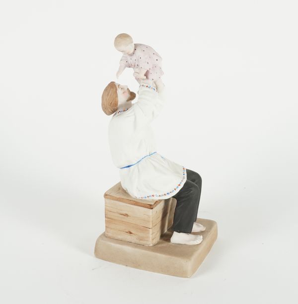 A RUSSIAN BISCUIT PORCELAIN FIGURE GROUP OF A FATHER AND CHILD