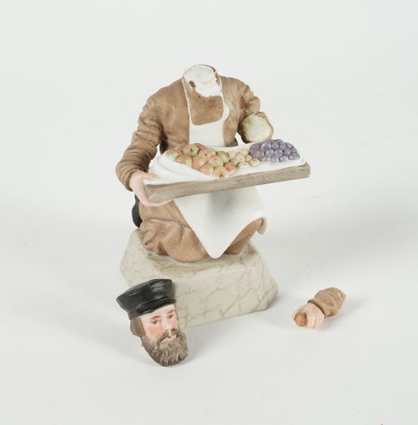 A RUSSIAN BISCUIT PORCELAIN FIGURE OF A FRUIT VENDOR