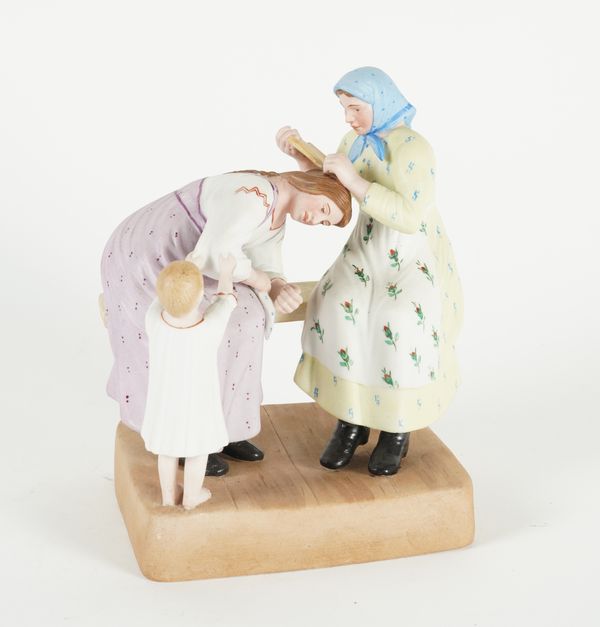 A RUSSIAN BISCUIT PORCELAIN FIGURE GROUP DEPICTING HAIR COMBING