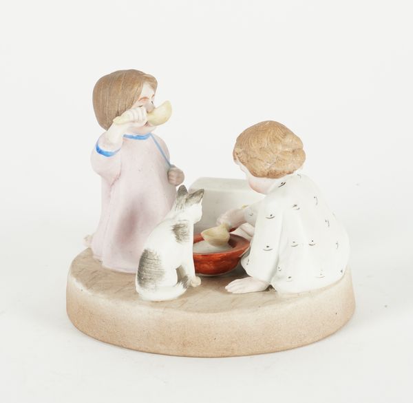 A RUSSIAN BISCUIT PORCELAIN FIGURE GROUP OF TWO SMALL CHILDREN AND A CAT DRINKING MILK FROM A BOWL