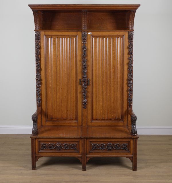 HAMPTON AND SONS; A CARVED OAK CUPBOARD BACK OPEN ARM SETTLE