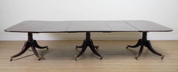 AN EARLY 19TH CENTURY MAHOGANY TRIPLE PILLAR EXTENDING DINING TABLE