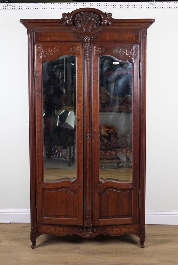 AN 19TH CENTURY FRENCH CARVED OAK MIRRORED TWO DOOR ARMOIRE