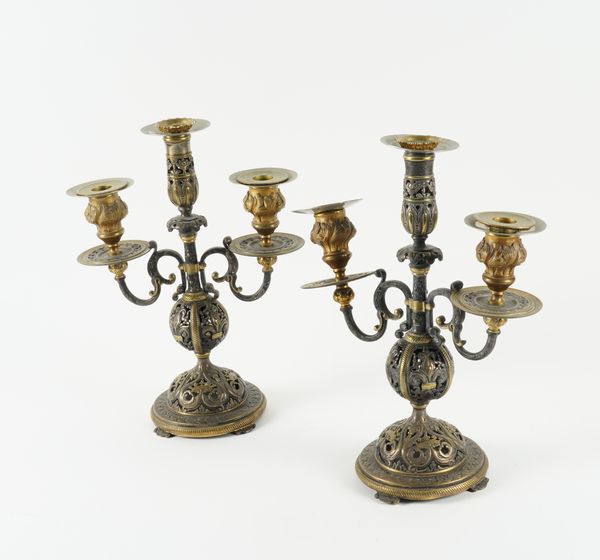 A PAIR OF SILVERED AND PARCEL GILT THREE  LIGHT CANDELABRA (2)