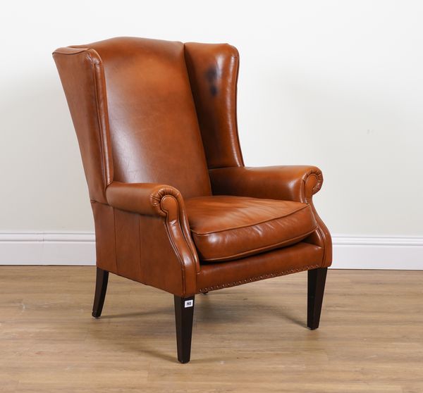 A 20TH CENTURY TAN LEATHER UPHOLSTERED WINGBACK ARMCHAIR