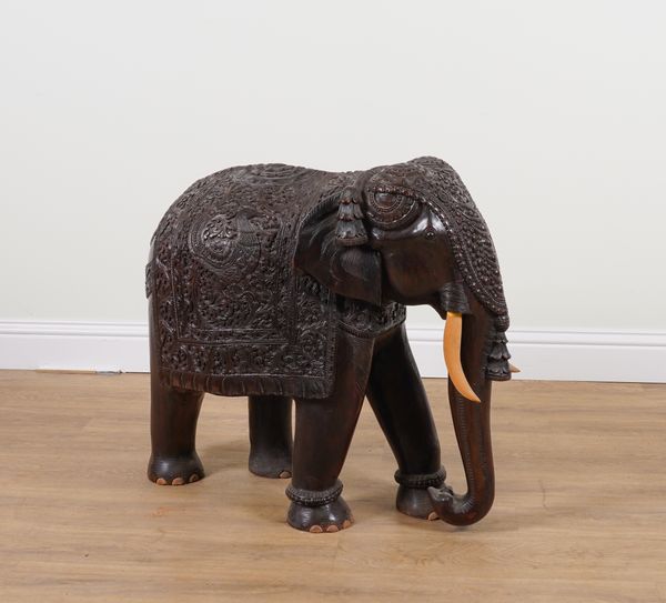 AN EARLY 20TH CENTURY LARGE CARVED HARDWOOD ELEPHANT