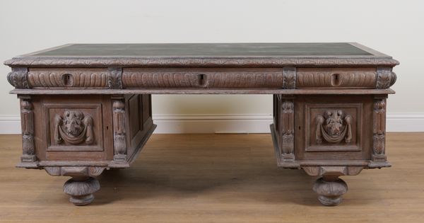 A 19TH CENTURY CONTINENTAL CARVED LIMED OAK PEDESTAL DESK (2)