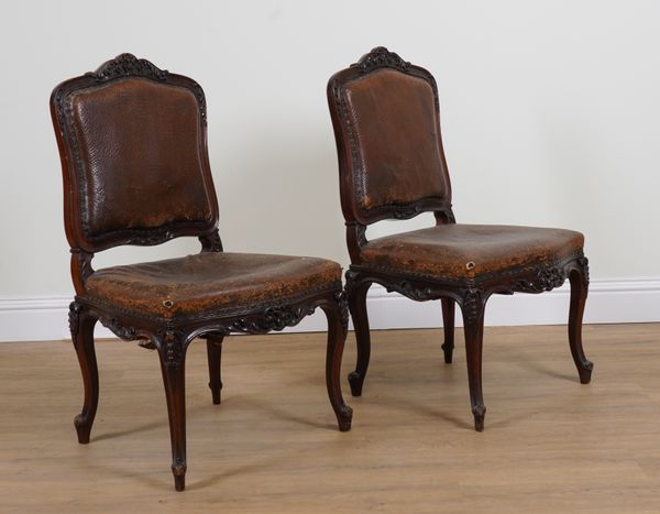 A PAIR OF LOUIS XV STYLE WALNUT LEATHER UPHOLSTERED SIDE CHAIRS (2)