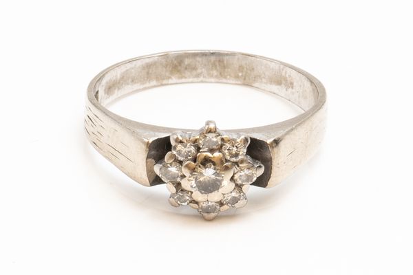 A WHITE GOLD AND DIAMOND NINE STONE CLUSTER RING