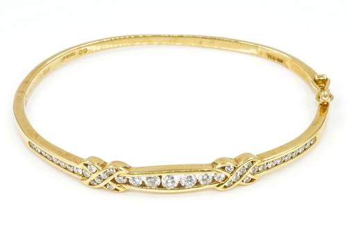 AN 18CT GOLD AND DIAMOND OVAL HINGED BANGLE