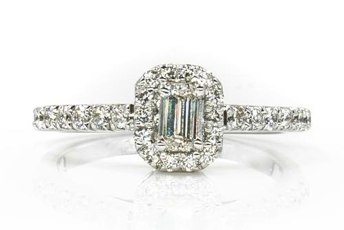 A WHITE GOLD AND EMERALD CUT DIAMOND RING