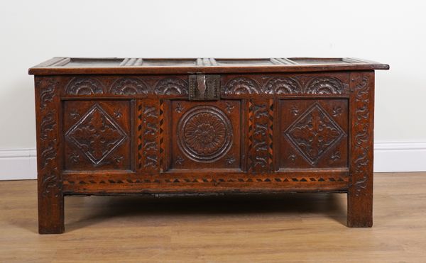 A 17TH CENTURY CARVED OAK PANEL COFFER