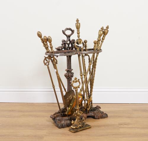A VICTORIAN BRASS LEAD WEIGHTED DOOR STOP; TOGETHER WITH A CAST-IRON STICK STAND AND THREE SETS OF BRASS FIRE-TOOLS (11)