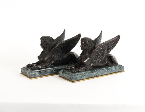 A PAIR OF PATINATED BRONZE WINGED RECUMBENT SPHINXES (2)