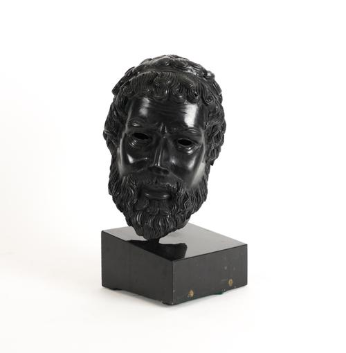A BRONZE PATINATED METAL HEAD OF A GREEK GOD OR SPARTAN AFTER THE ANTIQUE