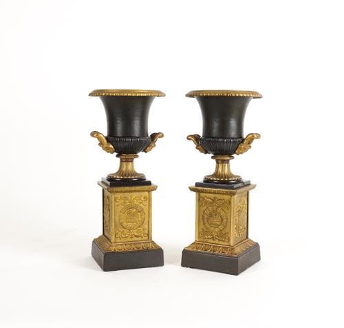 A PAIR OF EMPIRE STYLE PATINATED AND GILT METAL CAMPANA URNS ON PLINTHS (2)