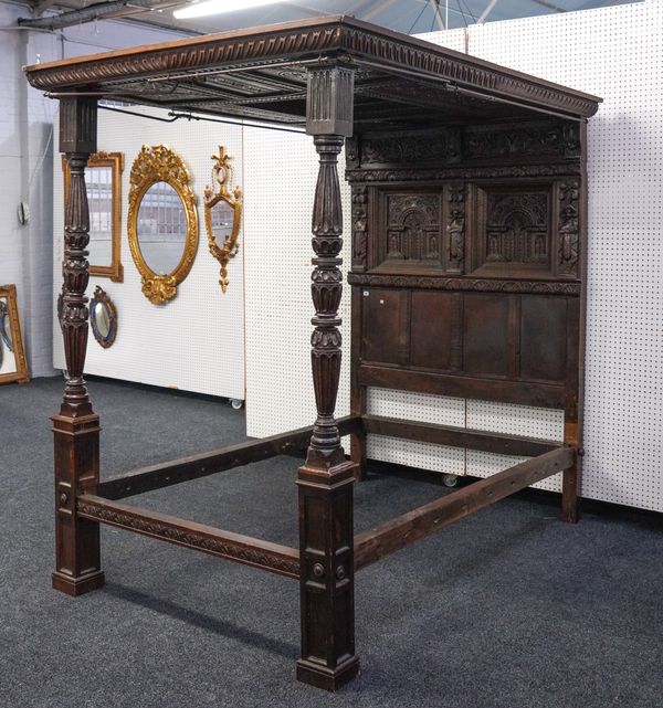 AN OAK FOUR POSTER BED WITH CARVED AND PANELLED CONOPY AND HEADBOARD