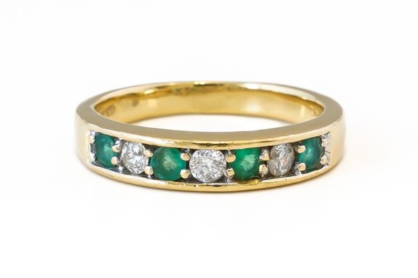 AN 18CT GOLD, EMERALD AND DIAMOND SEVEN STONE HALF ETERNITY RING