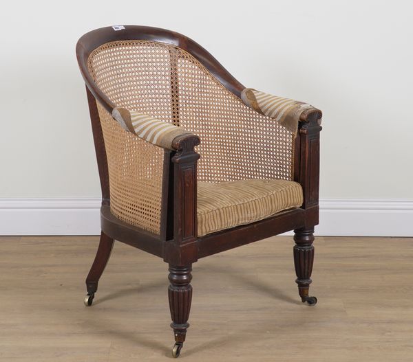 A LATE REGENCY WALNUT CANED BERGERE ARMCHAIR