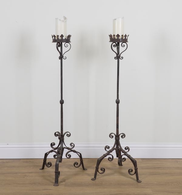 A PAIR OF GOTHIC REVIVAL WROUGHT IRON FLOOR STANDING CANDLE STICKS (2)