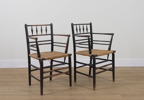 WILLIAM MORRIS; A PAIR OF EBONISED ASH SUSSEX OPEN ARMCHAIRS (2)