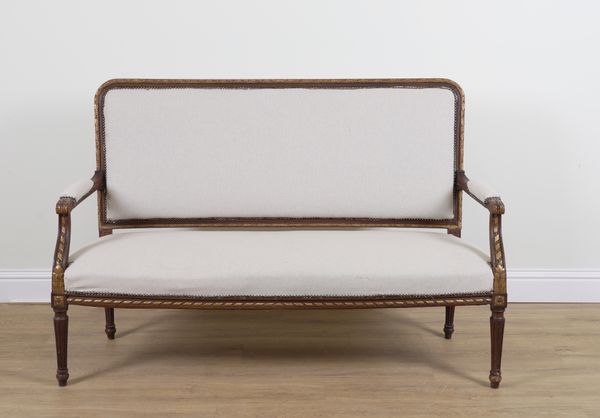 A LOUIS XVI STYLE PARCEL GILT STAINED BEECH OPEN ARM SETTEE