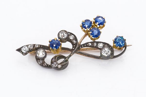 A GOLD BACKED AND SILVER SET SAPPHIRE AND DIAMOND SPRAY BROOCH