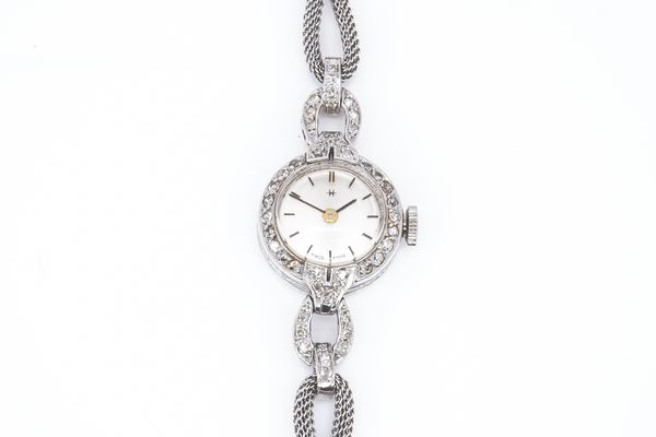 A PLATINUM CASED  AND DIAMOND SET LADY'S CIRCULAR CASED DRESS WRISTWATCH