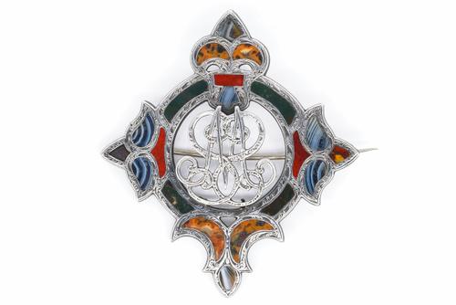A SCOTTISH SILVER AND VARICOLOURED AGATE BROOCH WITH A MONOGRAM TO THE CENTRE