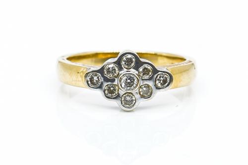 AN 18CT GOLD AND DIAMOND NINE STONE CLUSTER RING