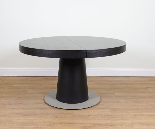 AN EBONISED ASH CIRUCULAR EXTEDNING DINING TABLE