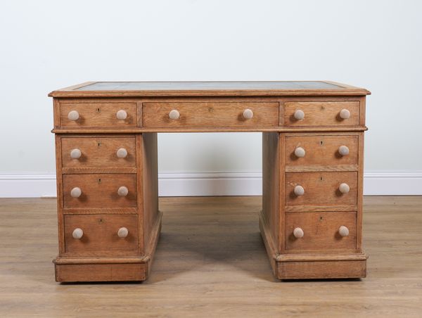 A VICTORIAN OAK NINE DRAWER PEDESTAL DESK