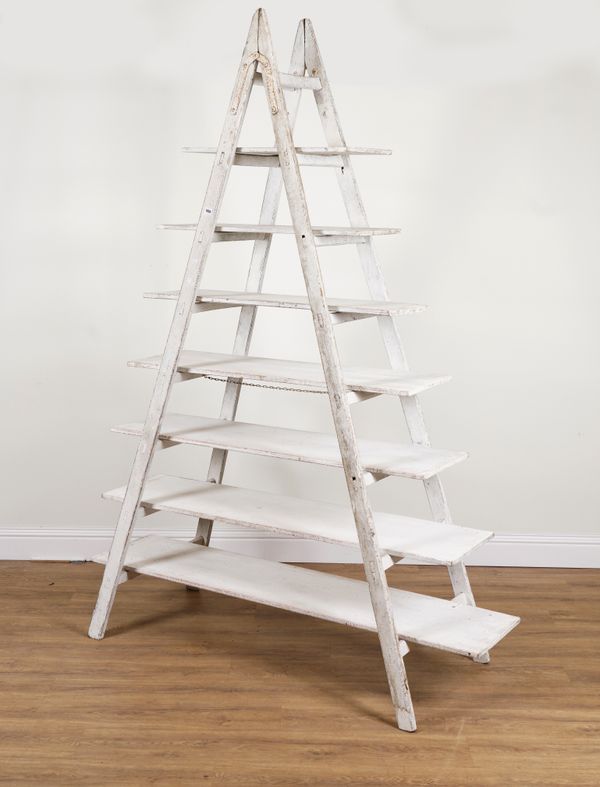 A SET OF SHELVES CONSTRUCTED FROM A PAINTED EIGHT RUNG A-FRAME STEP LADDER