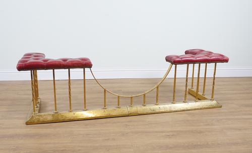 A BRASS AND RED LEATHER CLUB FENDER