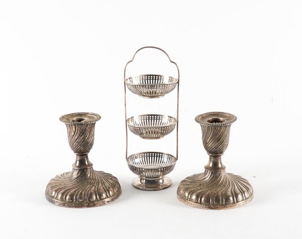 A PAIR OF SILVER CANDLESTICKS AND A SILVER THREE TIER STAND (2)