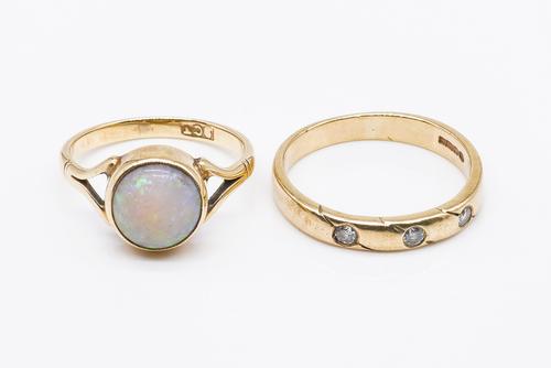 A GOLD AND OPAL RING AND A 9CT GOLD AND THREE STONE DIAMOND RING (2)