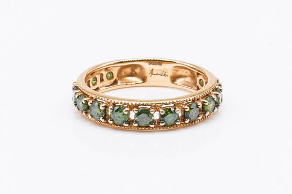 A 18CT GOLD AND TREATED GREEN DIAMOND FOURTEEN STONE ETERNITY RING