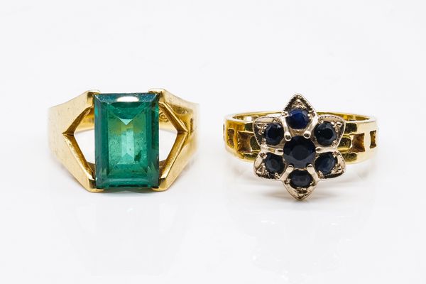 AN 18CT GOLD AND SAPPHIRE SEVEN STONE CLUSTER RING AND A GOLD AND SYNTHETIC GREEN SPINEL SET SINGLE STONE RING (2)