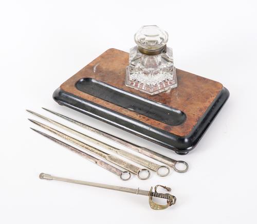 A MINIATURE INFANTRY OFFICER'S DRESS SWORD PAPER KNIFE AND A BURR WOOD DESK STAND WITH INKWELL (6)