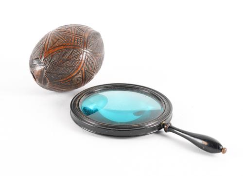 OF SAILOR’S FOLK ART INTEREST: A CARVED COCONUT ‘BUG BEAR’ POWDER FLASK AND A VICTORIAN EBONISED MAGNIFYING GLASS (2)