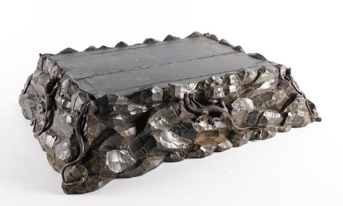 A CARVED EBONISED WOOD DISPLAY PLINTH MOUNTED WITH SILVERED METAL LIZARDS