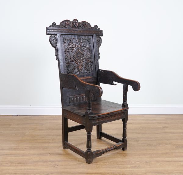 A 17TH CENTURY STYLE CARVED OAK WAINSCOT ARMCHAIR